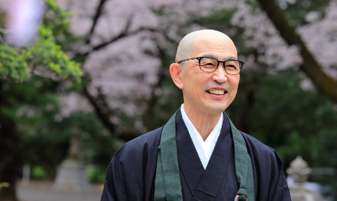 總寧寺住職の照井文隆さんの写真。境内で笑顔のポートレート